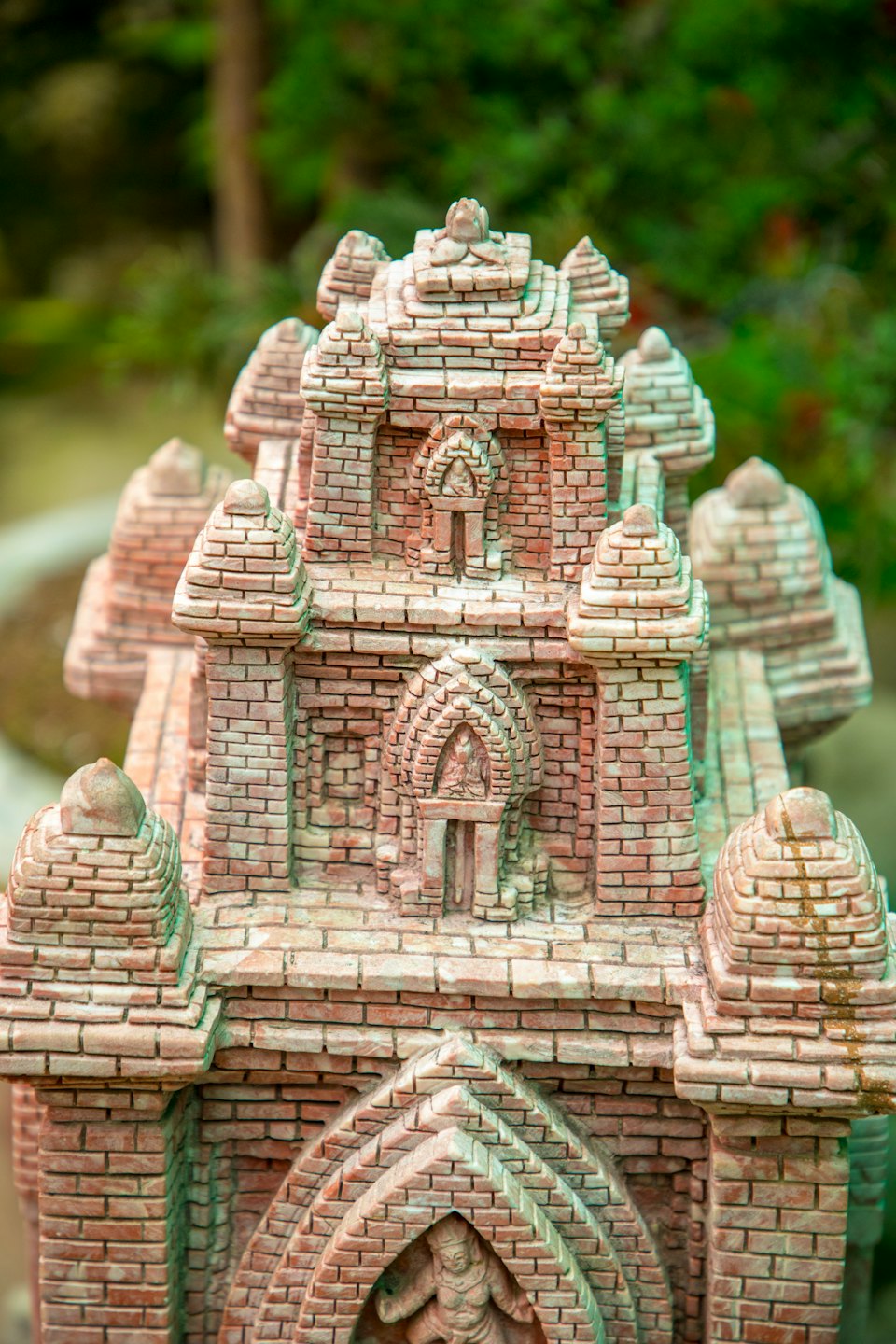 Skomplikowany miniaturowy model budynku z cegły z łukami i iglicami.